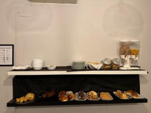a shelf with different types of pastries and plates at Relais Stibbert Florence in Florence