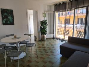 sala de estar con mesa, sillas y ventana en Lloret Centre Apartment, en Lloret de Mar