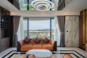 salon z kanapą i dużym oknem w obiekcie Khách sạn cao cấp citadines marina HẠ LONG w Ha Long