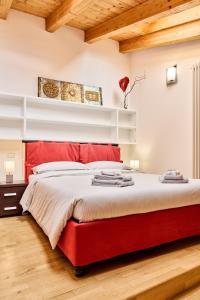 - un lit rouge dans une chambre dotée de plafonds en bois dans l'établissement Appartamento Dilva, à Vigolo Vattaro