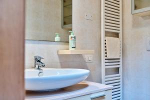 La salle de bains est pourvue d'un lavabo blanc et d'un miroir. dans l'établissement Appartamento Dilva, à Vigolo Vattaro