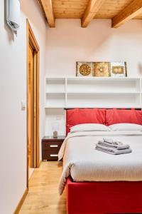 - une chambre avec un lit rouge et un banc rouge dans l'établissement Appartamento Dilva, à Vigolo Vattaro