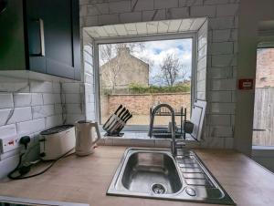 a kitchen with a sink and a large window at Studio flat in York in York