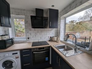 a kitchen with a sink and a washing machine at Stylish York Studio in York