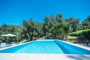 a swimming pool in a villa with trees at Armoniahousesuites in Perítheia