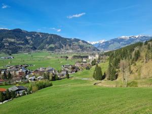 a small town in a green valley with mountains at Hotel Garni Panorama Guggenbichl in Kaprun