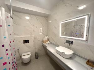 Baño blanco con aseo y lavamanos en Hostal Sorbas, en Sorbas