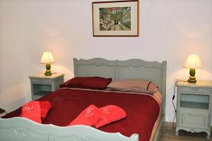 Un dormitorio con una cama con almohadas rojas. en La Bigotière avec clim et jardin, en Arles