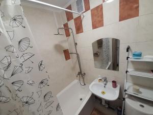 Апартаменти біля Автовокзалу في روفنو: حمام مع حوض وستارة دش مع رسومات على الحائط
