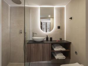 uma casa de banho com um lavatório e um espelho em Copal Experience The Port em Chania Town