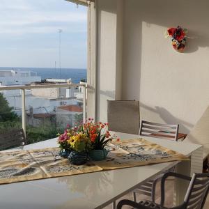 a table with flowers on it with a view of the ocean at Dimora Kalypso in Polignano a Mare