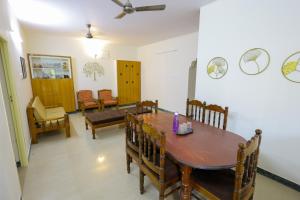 a dining room with a wooden table and chairs at Izi Transit Stay in Chennai
