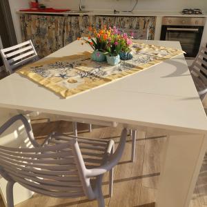 a white dining room table with flowers on it at Dimora Kalypso in Polignano a Mare +39 photos
