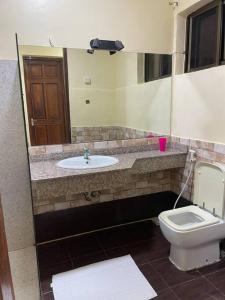 a bathroom with a sink and a toilet at Beautiful 4 bedroom house in Masaki with parking in Dar es Salaam