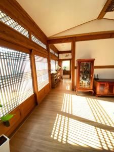 an empty room with sun shining through the windows at Stay Sayu Hanok in Gyeongju