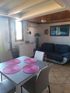 ein Wohnzimmer mit einem Tisch mit rosa Platten darauf in der Unterkunft Appartement Port Rose 2 in Leucate