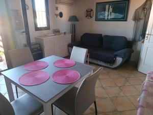 einen Esstisch mit vier rosa Platten darauf in der Unterkunft Appartement Port Rose 2 in Leucate