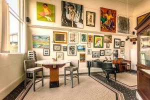 a room with a table and a piano and pictures on the wall at Luxury 1920s Bank Loft, Art Gallery & Music Space in Tomales, CA in Tomales