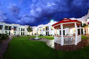 a large white building with a gazebo in a yard at Ramada by Wyndham Kingman in Kingman
