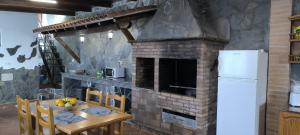 ラ・オロタバにあるCasa Chemarのキッチン(レンガ造りの暖炉、テーブル、椅子付)