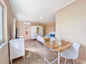 a living room with a table and a bed at Cantinho da Lourdes e Tonito Nº 136193/AL in Miro