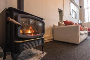 a fireplace in a living room with a couch and a chair at Luxury 1920s Bank Loft, Art Gallery & Music Space in Tomales, CA in Tomales +34 photos