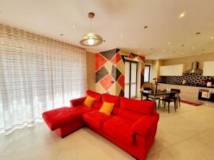 a living room with a red couch and a table at Oasi del Monferrato - appartamento rosso in Mombercelli