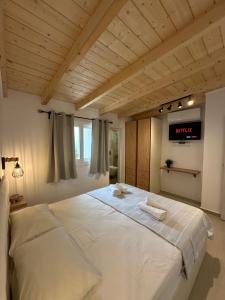 a bedroom with a large bed with a tv on the wall at Kefalonian 360° Sunrise in Kaligata