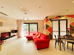 sala de estar con sofá rojo y mesa en Oasi del Monferrato - appartamento rosso, en Mombercelli