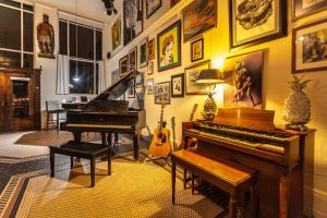 a living room with a piano and a guitar at Luxury 1920s Bank Loft, Art Gallery & Music Space in Tomales, CA in Tomales