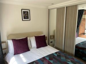 a hotel room with a bed with purple pillows at Staycation York at Cocoa Suites in York