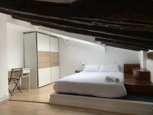 a bedroom with a white bed and a desk at Bilbao Jardines in Bilbao