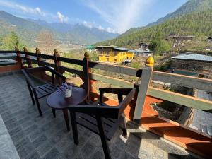 a table and chairs on a balcony with a view at Taktsangri-La in Drugyel Dzong
