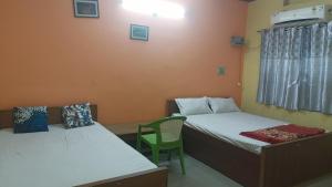 um quarto com duas camas e uma cadeira em Sanskriti paying guest house em Varanasi
