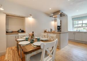 uma cozinha e sala de jantar com uma mesa de madeira e cadeiras em Wyvern Cottage em Swanage