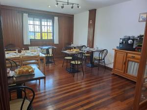 Hostal Boavista في Costoia: غرفة طعام مع أرضيات خشبية وطاولات وكراسي