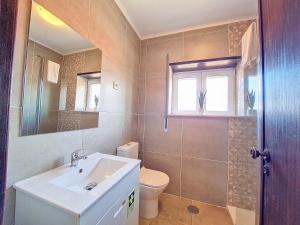 a bathroom with a sink and a toilet and a mirror at Cantinho da Lourdes e Tonito Nº 136193/AL in Miro +74 photos