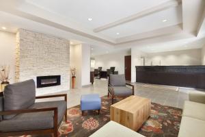 a lobby with a fireplace and chairs and a table at Country Inn & Suites by Radisson, Fresno North, CA in Fresno