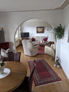 a living room with a couch and a table at Ferienwohnung Leni erstes OG inkl Balkon Gartenblick kostenfreier Parkplatz stadtnah aber ruhig gelegen in Meppen +3 photos