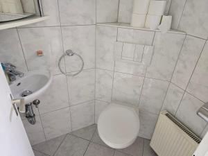 a bathroom with a toilet and a sink at Sarahs Ferienhaus in Raunheim +3 photos
