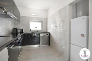 una cucina bianca con lavandino e frigorifero di Villa Casablanca ad Albufeira