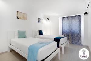 1 dormitorio con 2 camas y ventana en Villa Casablanca, en Albufeira