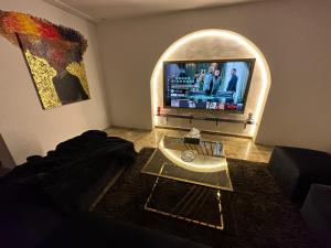 een woonkamer met een tv en een tafel bij Modern 1-Bedroom apartment in Zamalek in Caïro