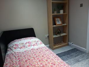 a bedroom with a bed and a book shelf at Jasmine Haus in Moortown