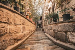 an alley with a stone wall and plants at Vintage Cave House Hotel in Göreme
