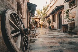 an alley in an old town with a wooden wheel at Vintage Cave House Hotel in Göreme