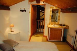 ein Schlafzimmer mit einem Bett und ein Badezimmer mit einem Waschbecken in der Unterkunft Gîtes du Vieux Tilleul, l'Ecurie. in Marseillette