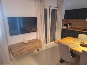 una sala da pranzo con tavolo e TV a parete di Residence Porec V a Poreč (Parenzo)