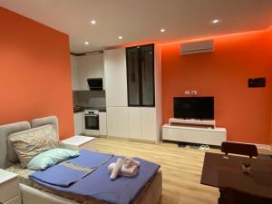 a living room with orange walls and a couch at Tirana Center Apartaments in Tirana