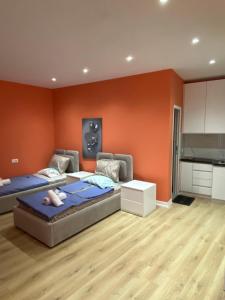 a bedroom with two beds and an orange wall at Tirana Center Apartaments in Tirana